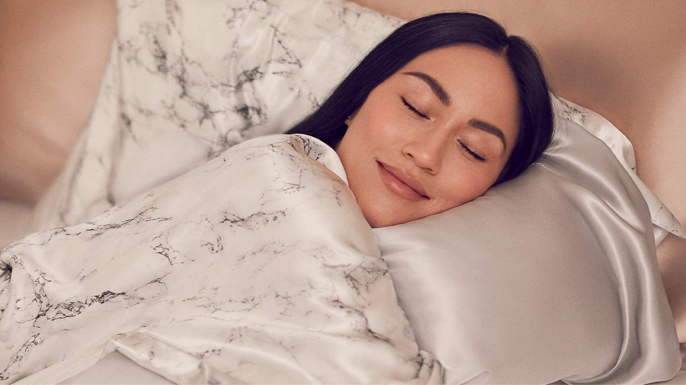 Three champagne-colored silk pillowcases with smooth, glossy textures and delicate stitching details